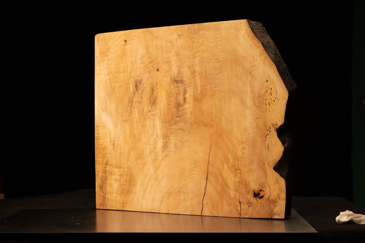 Front perspective of a climate-stable architectural wood block displaying a smooth golden face and heavily charred side edge. 