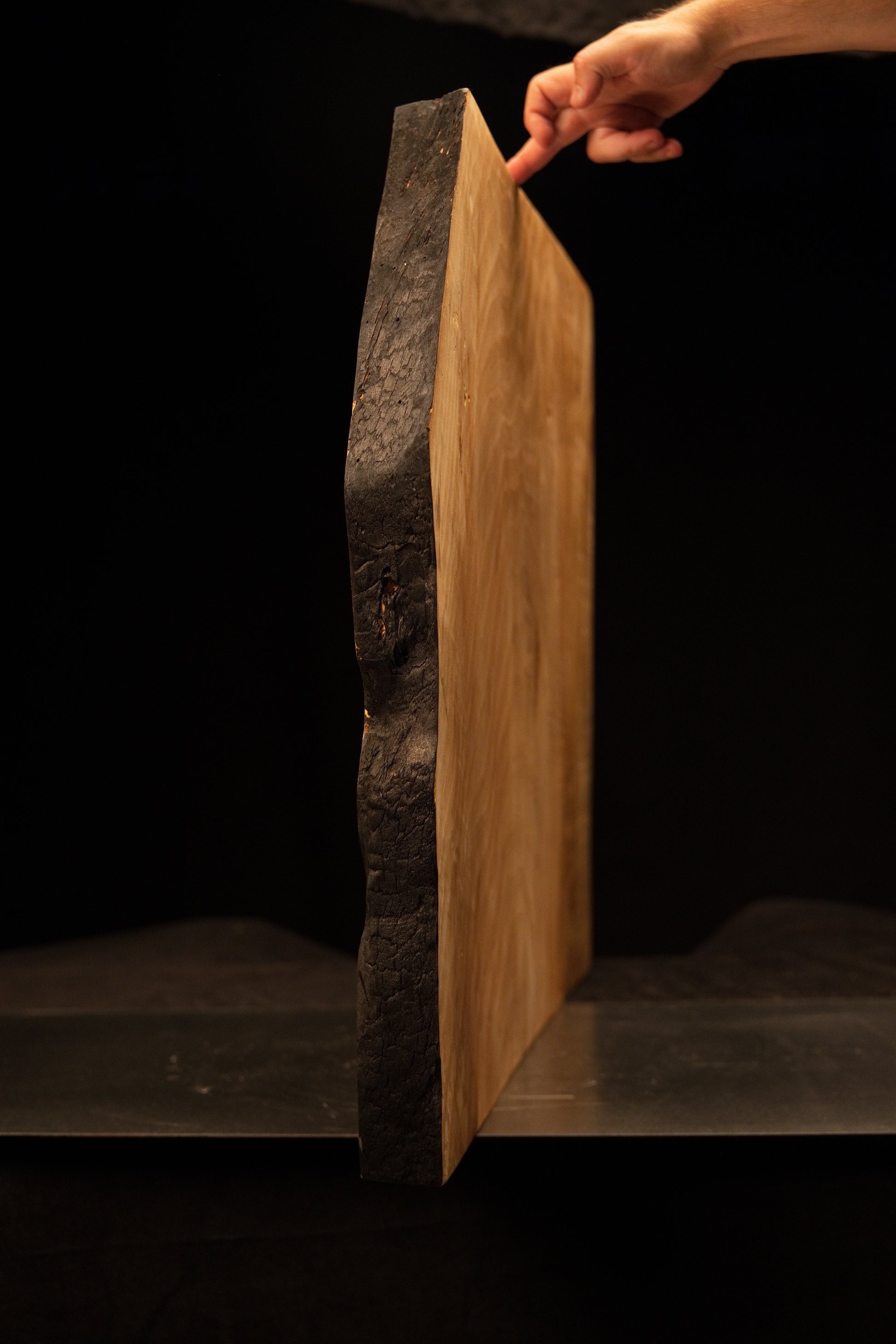 Full side profile of the heavily textured dark charred face on a dimensionally stable structural wooden block for luxury spaces. 