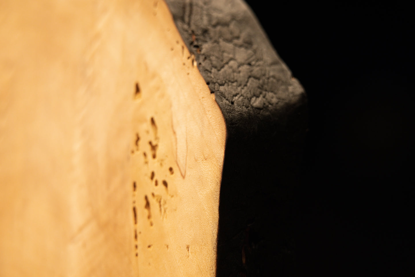 Extreme close-up of tiny organic anomalies and distinct surface pitting across the flat polished face of a climate-stable timber. 