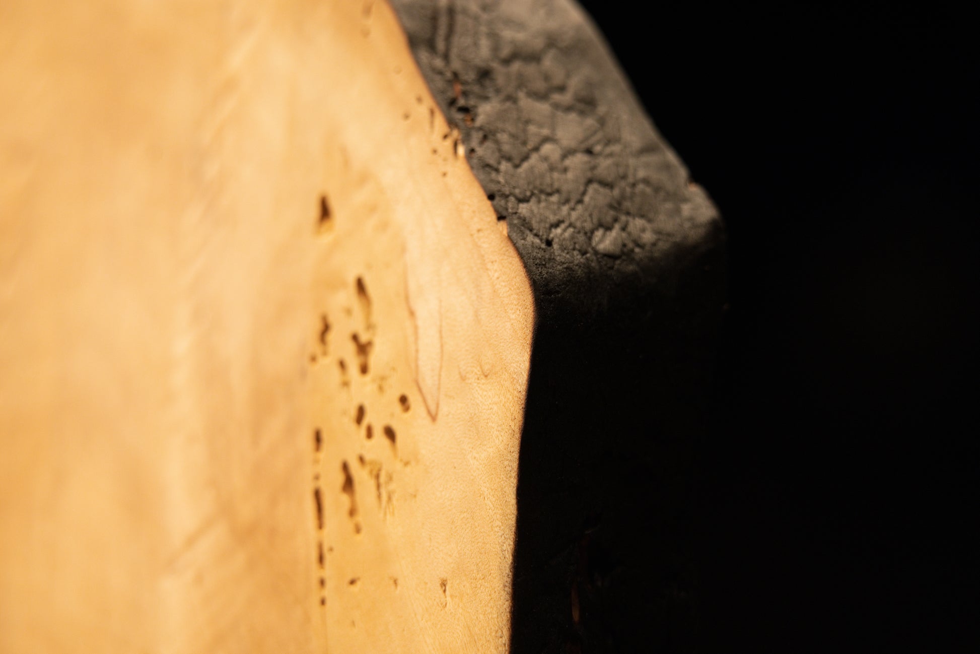 Extreme close-up of tiny organic anomalies and distinct surface pitting across the flat polished face of a climate-stable timber. 