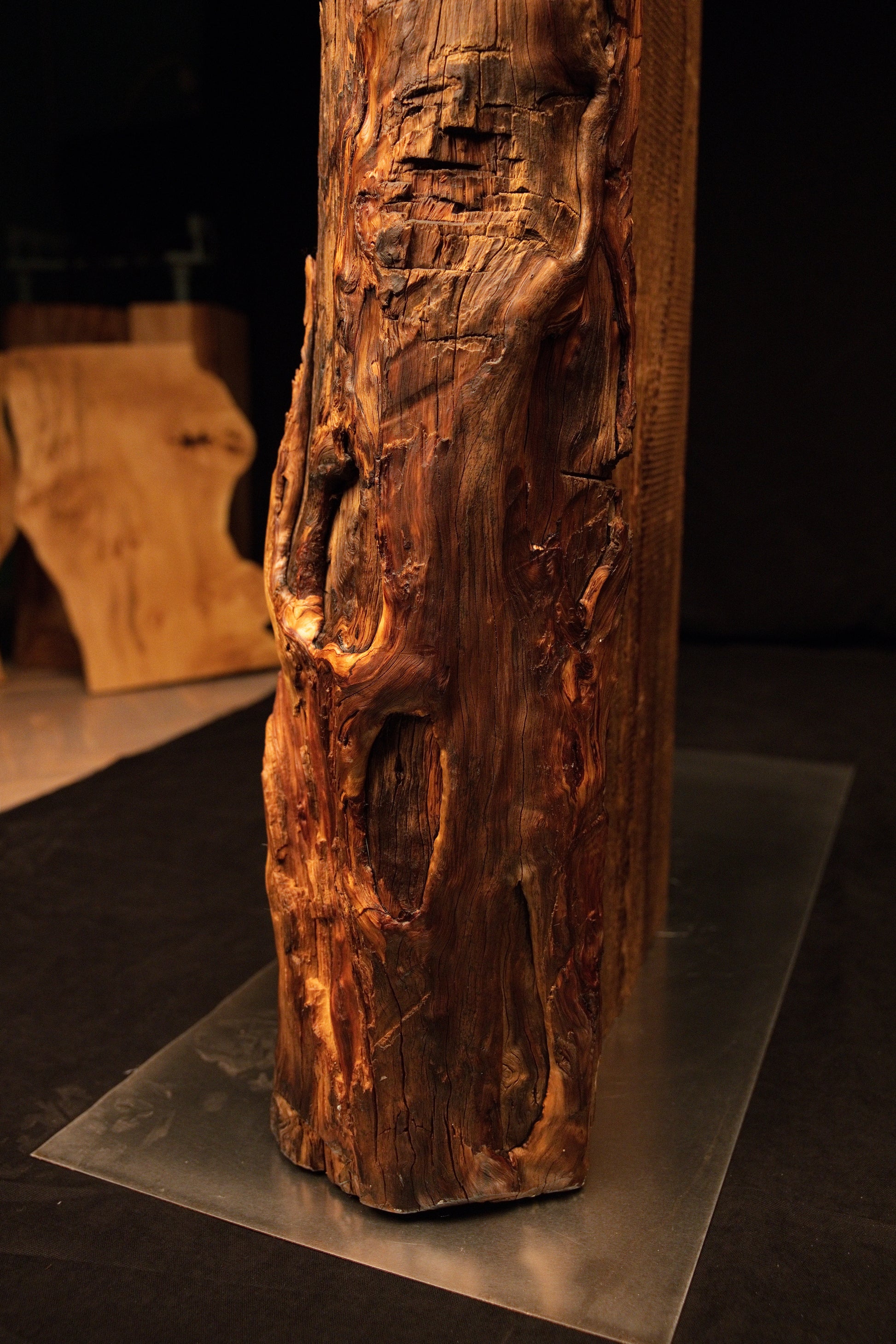Detailed view of deep vertical channeling and a prominent dark knot on the face of a floor-heating stable architectural log. 