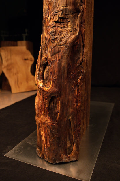 Detailed view of deep vertical channeling and a prominent dark knot on the face of a floor-heating stable architectural log. 