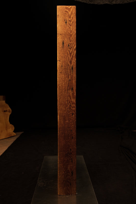 Full vertical view of a tall climate-stable structural timber beam displaying deeply textured straight golden wood grain lines. 