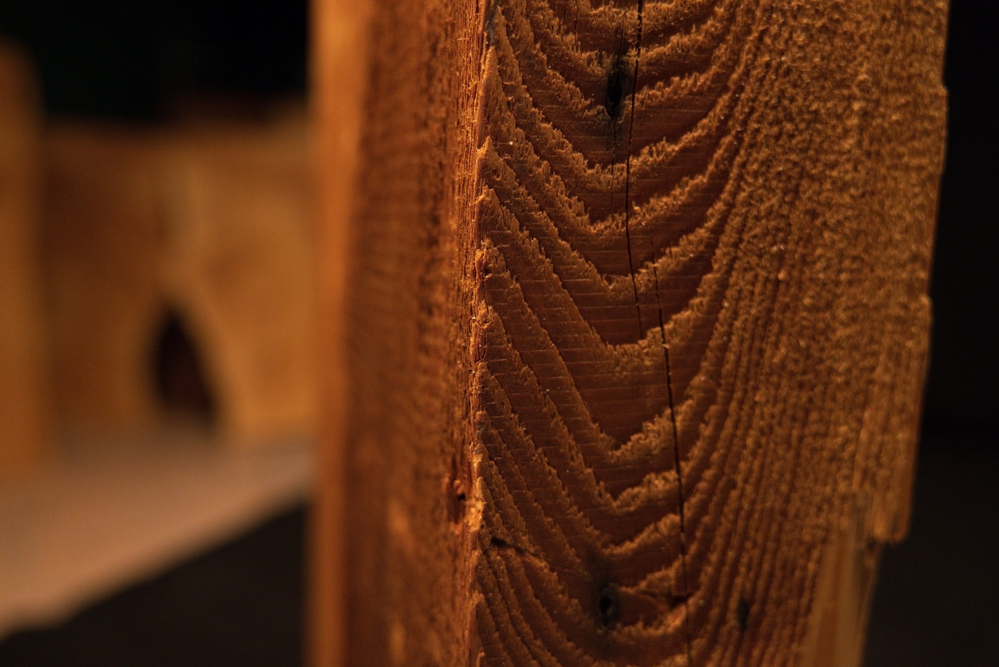 Close perspective of the sharp vertical corner edge on a fully stabilized heritage timber showing exceptionally dense wood fibers. 