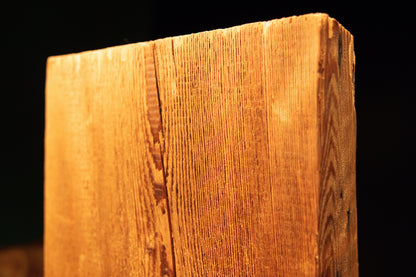 Angled close detail of the flat horizontal top cut meeting deeply ridged vertical fibers on a commercial structural timber beam. 