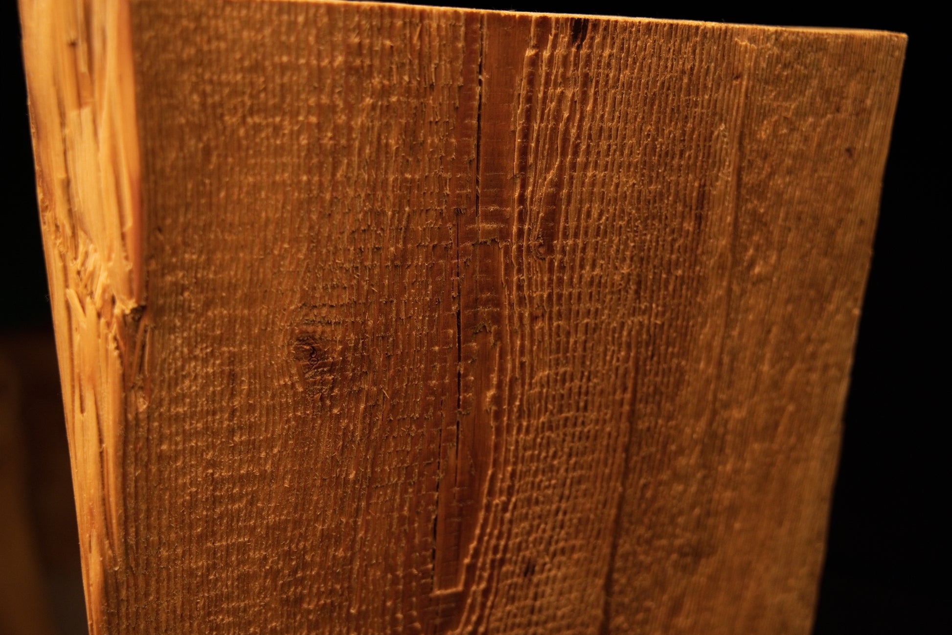Macro focus on a shallow vertical fissure and historic tool marks running along the face of a perfectly stabilized wood block. 