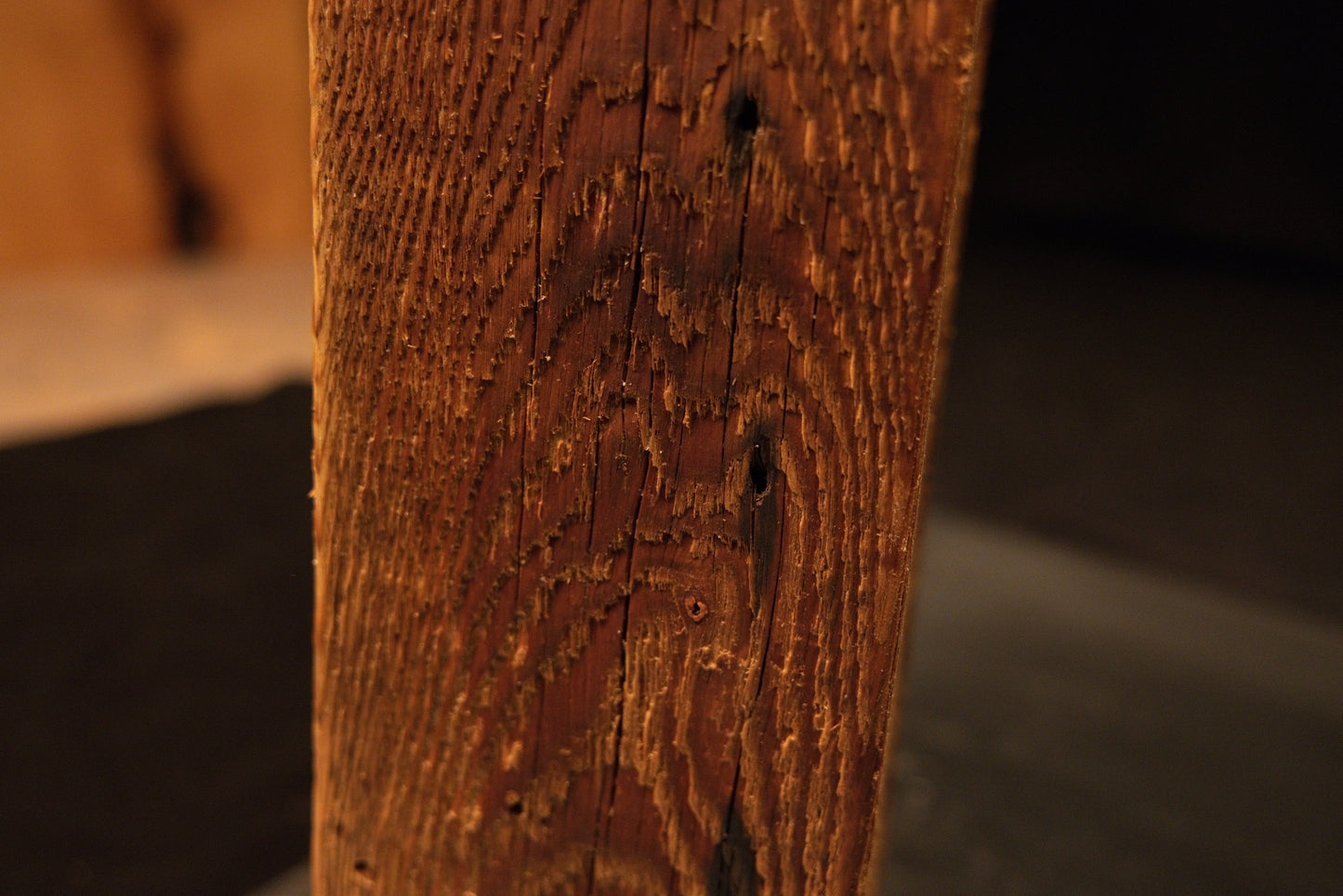 Detailed focus on extremely dense vertical wood fibers and small biological inclusions on a climate-stable architectural log face. 