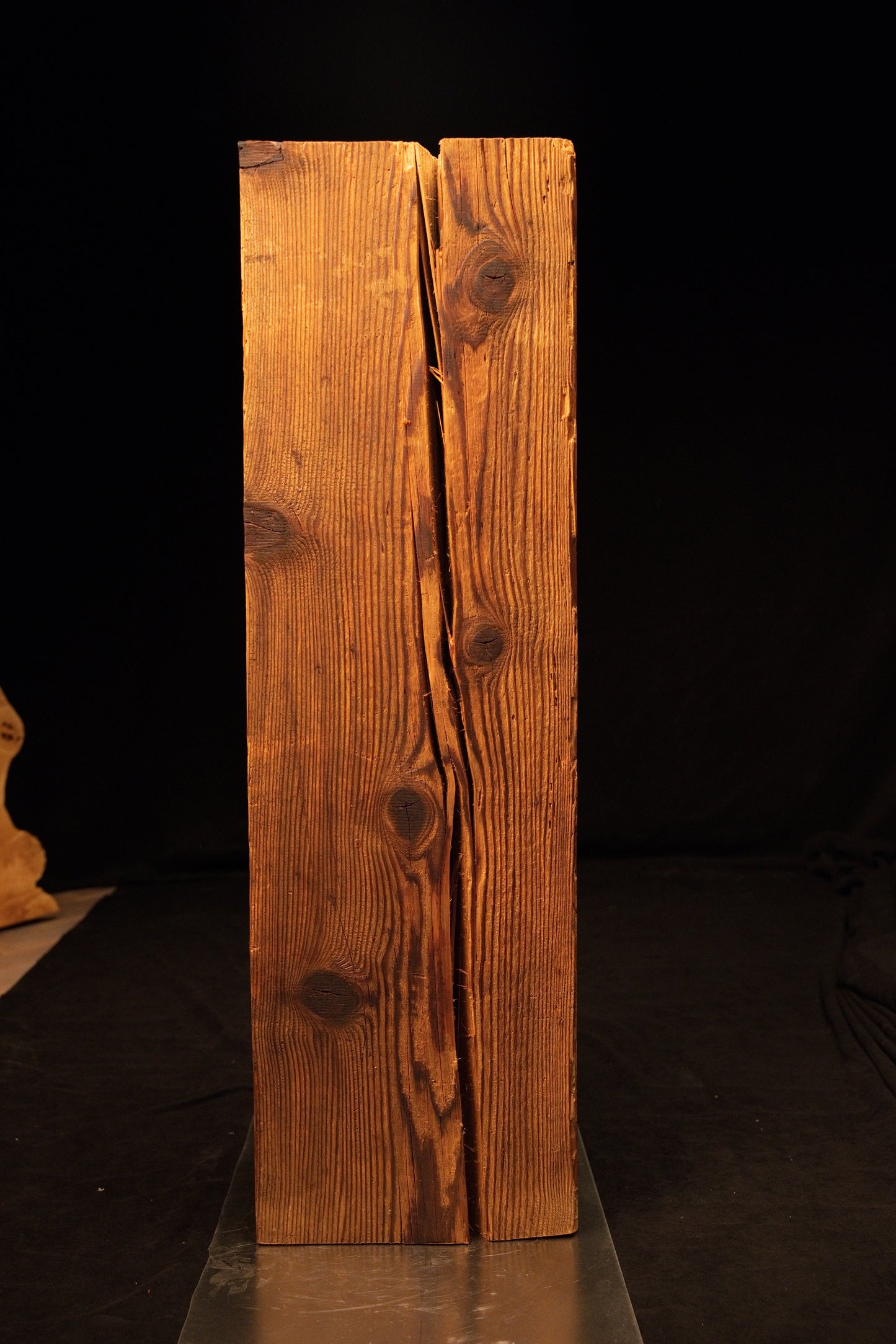 Straight front perspective of a floor-heating compatible wooden block revealing a deep vertical split and natural dark knots. 