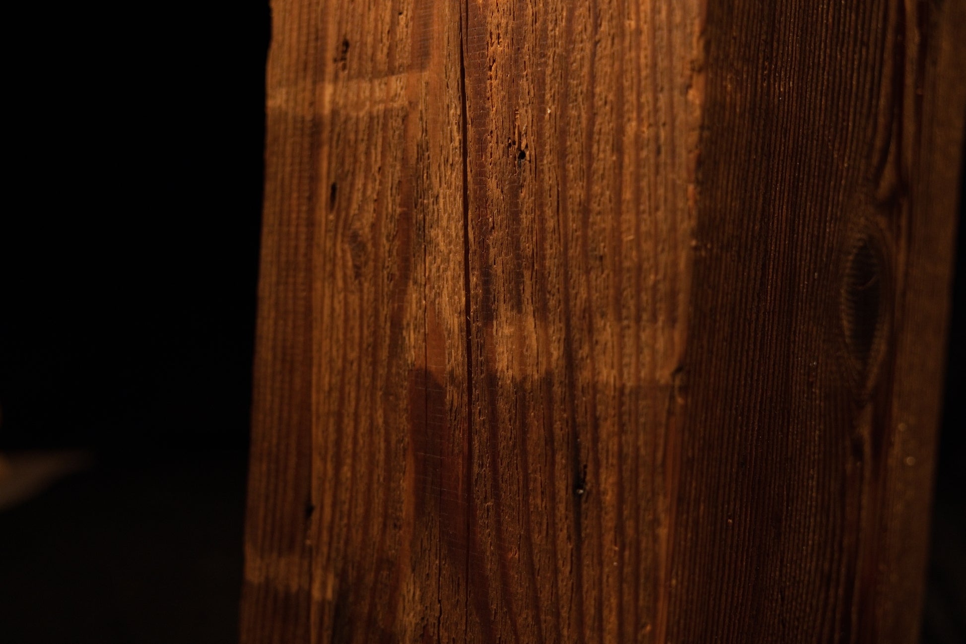 Macro view of a deep vertical fissure splitting the top precision cut edge on a climate-stable architectural timber block. 