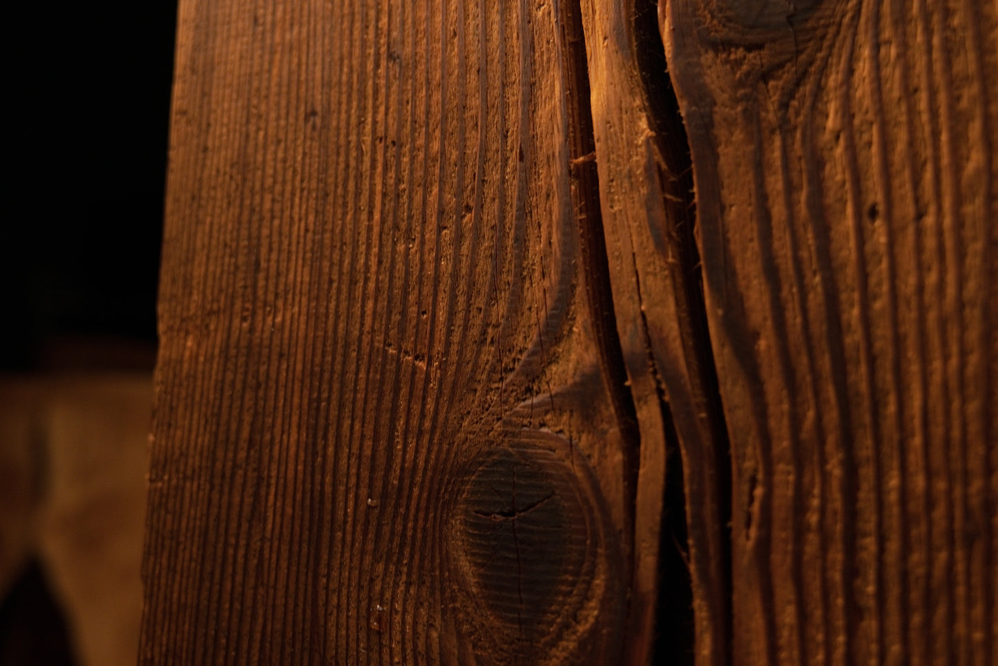 Close-up of wood grain curving gracefully around a deep vertical split in the face of a climate-stable commercial timber. 