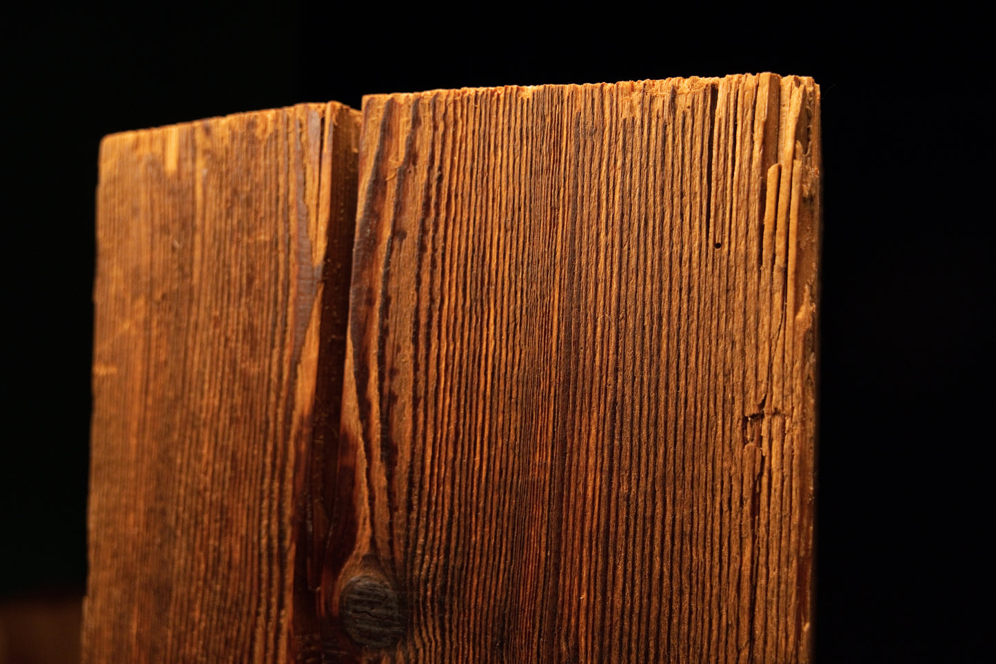 Macro view of a deep vertical fissure splitting the top precision cut edge on a climate-stable architectural timber block.  