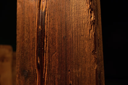 Macro focus on extremely dense vertical wood fibers and a dark biological knot on a floor-heating compatible structural log.  