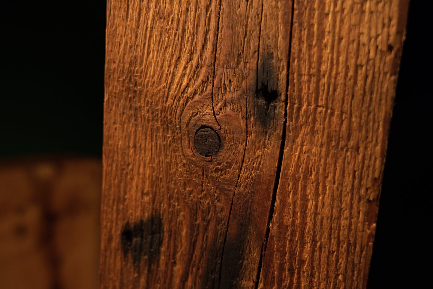 Close-up of wood grain curving gracefully around a deep vertical split in the face of a climate-stable commercial timber.  