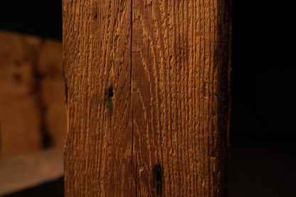 Extreme close-up of a dark joinery void positioned precisely on the vertical corner of a highly stabilized structural log.  