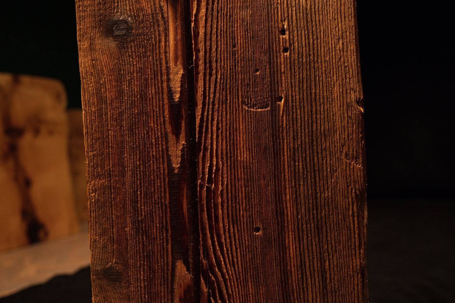 Extreme macro capturing sweeping vertical grain lines curving around a small dark knot on a climate-stable timber piece.  