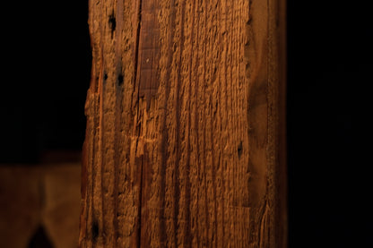 Detailed focus on extremely dense vertical wood fibers and small biological inclusions on a climate-stable architectural log face.  