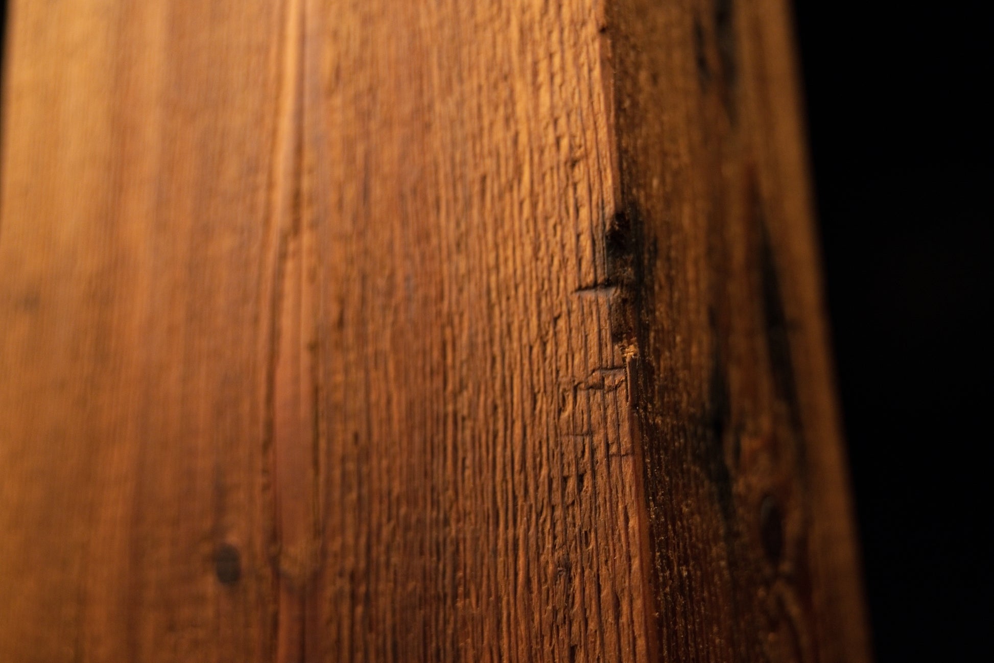 Extreme close-up of a long jagged vertical split running down the face of a floor-heating compatible architectural wood block.  