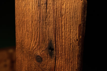 Close view displaying highly textured vertical grain and multiple dark biological knots on a pristine structural centerpiece.  