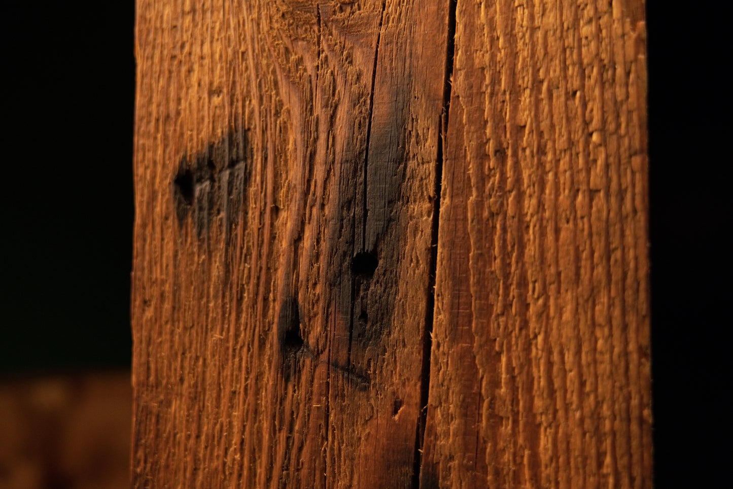 Detailed macro of a deep vertical crevice featuring jagged organic edges on a climate-proof biophilic architectural timber piece.  
