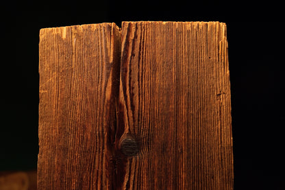 Detailed perspective of a deep vertical split revealing dark internal textures within a highly stabilized biophilic wood piece.  