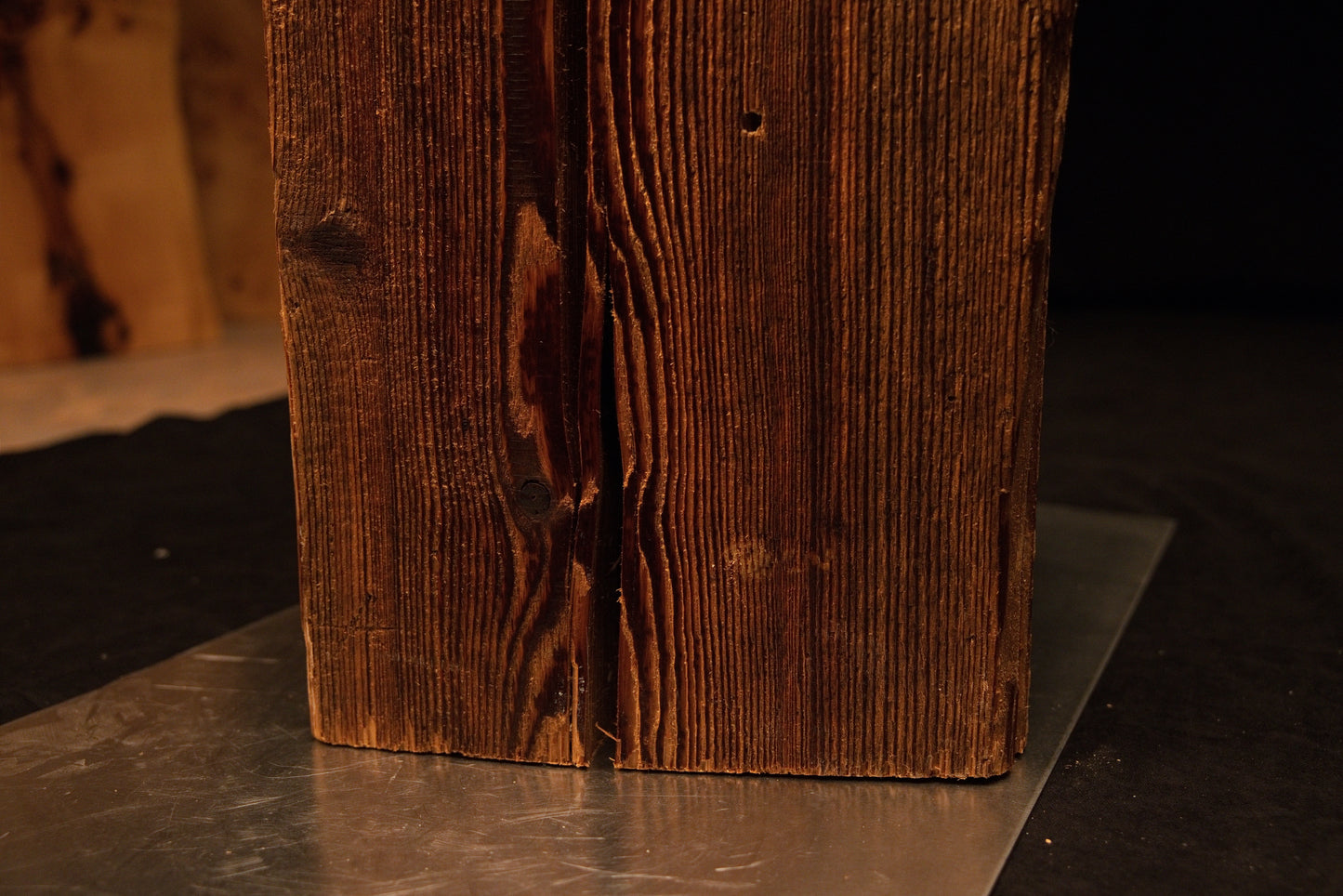 Extreme close-up capturing dense vertical grain lines terminating precisely at the flat cut base of an architectural timber block.  