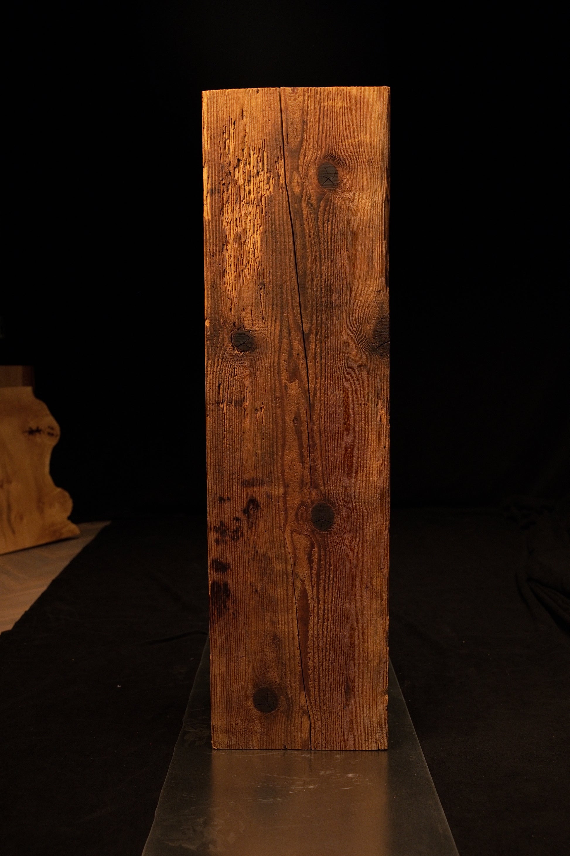 Straight front perspective of a floor-heating compatible wooden block revealing a prominent vertical split and dark knots. 