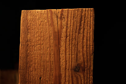 Macro focus on deeply textured vertical grain lines and a small dark knot near the upper face of a biophilic architectural slab. 