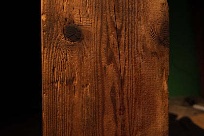 Macro focus on a large circular dark knot located near the upper edge of a floor-heating compatible architectural block. 