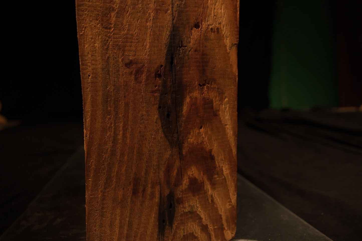 Lower face close-up showing tight vertical grain patterns curving around a dark biological inclusion on a stable wood beam. 