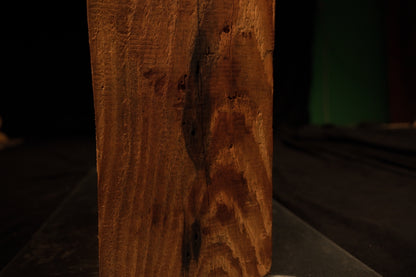 Lower face close-up showing tight vertical grain patterns curving around a dark biological inclusion on a stable wood beam. 