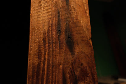 Extreme macro capturing furrowed golden wood fibers and a dark biological inclusion on a museum-quality interior timber block. 