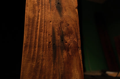 Detailed macro close-up of shallow surface pitting and vertical grain lines running along the face of a structural timber block. 
