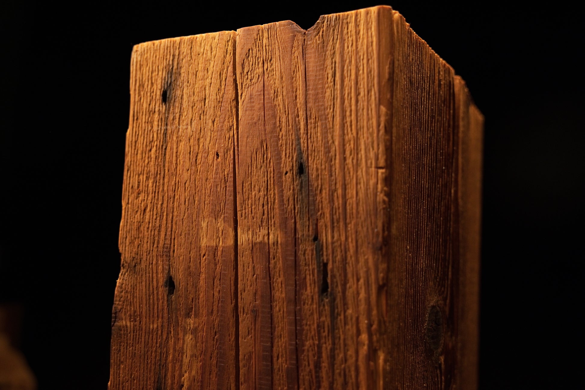 Detailed view of the upper beam section featuring tiny pinholes and dark knot marks along a fine vertical crack. 
