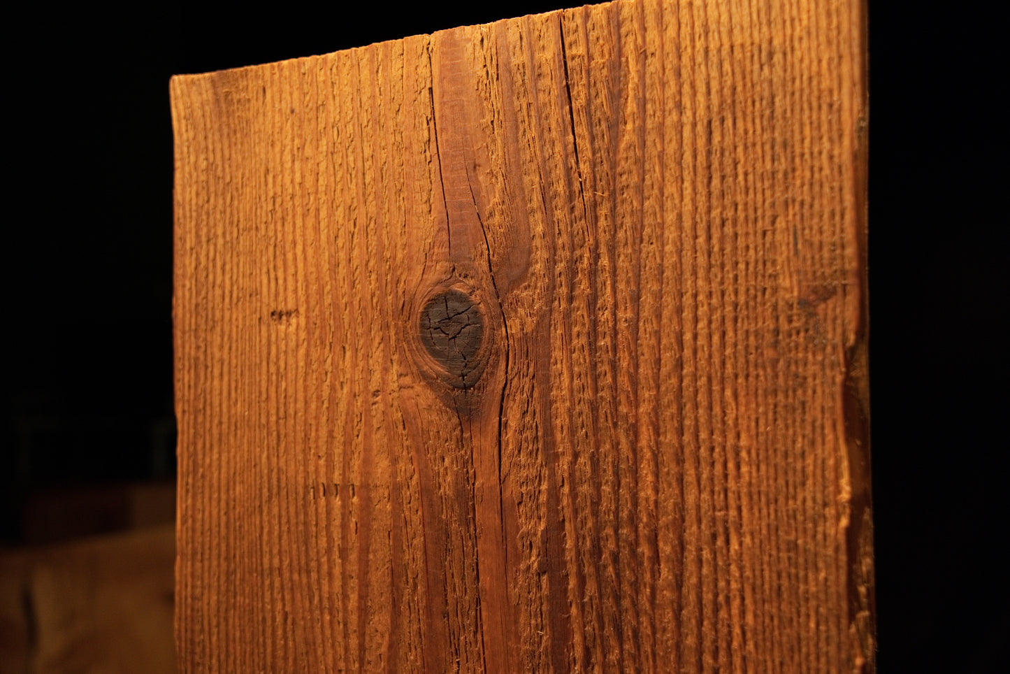 Detailed frontal view of the upper timber section centered on a prominent dark circular knot surrounded by straight grain. 