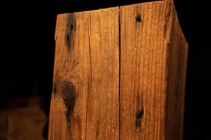 Close perspective of the top wooden beam area revealing a straight vertical split and two dark embedded knots. 