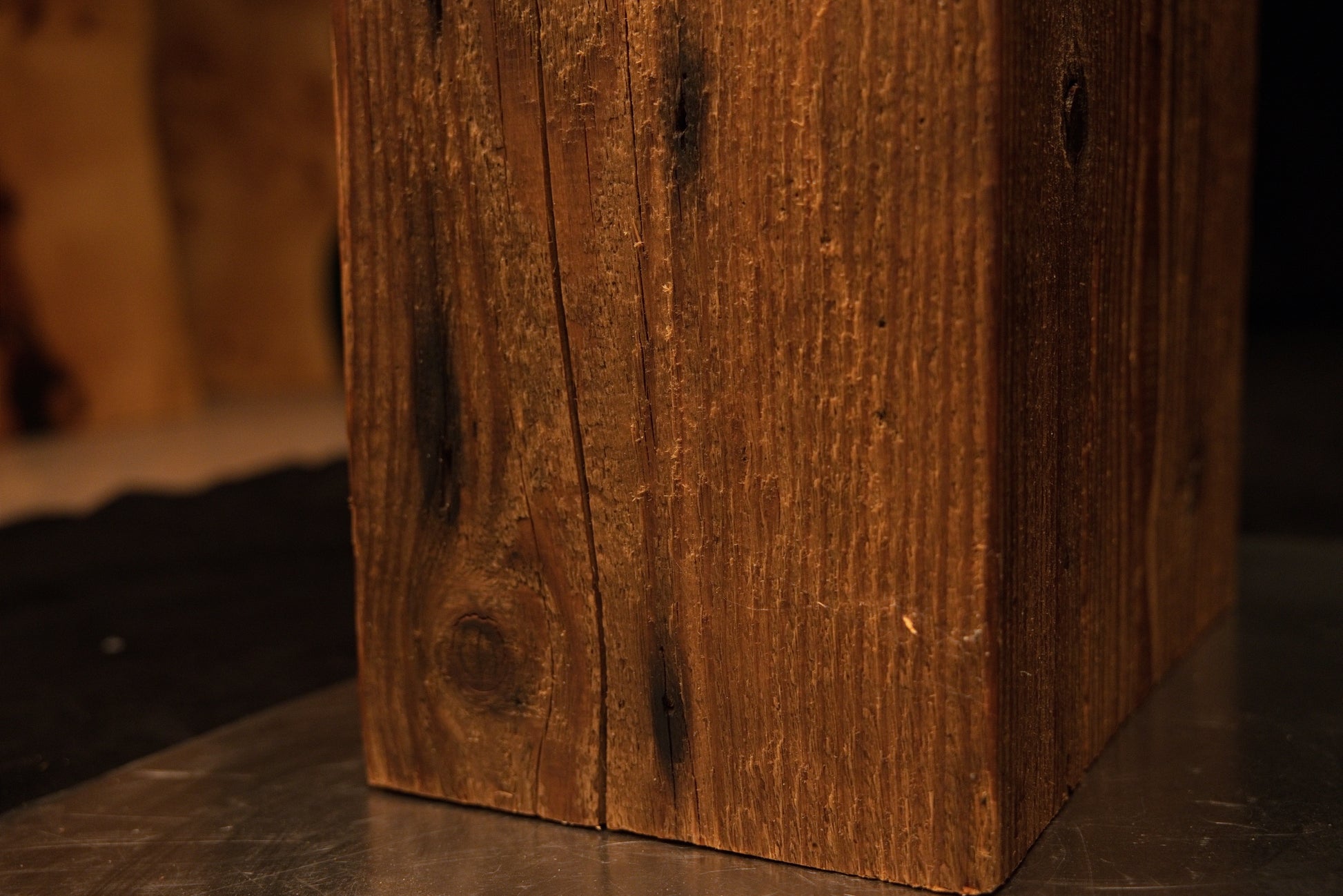 Close-up view of the lower corner section on a vertical timber column showing tight grain meeting the base. 