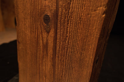 Macro view focusing on tight vertical grain lines and a small dark circular knot on the side of the wooden column. 