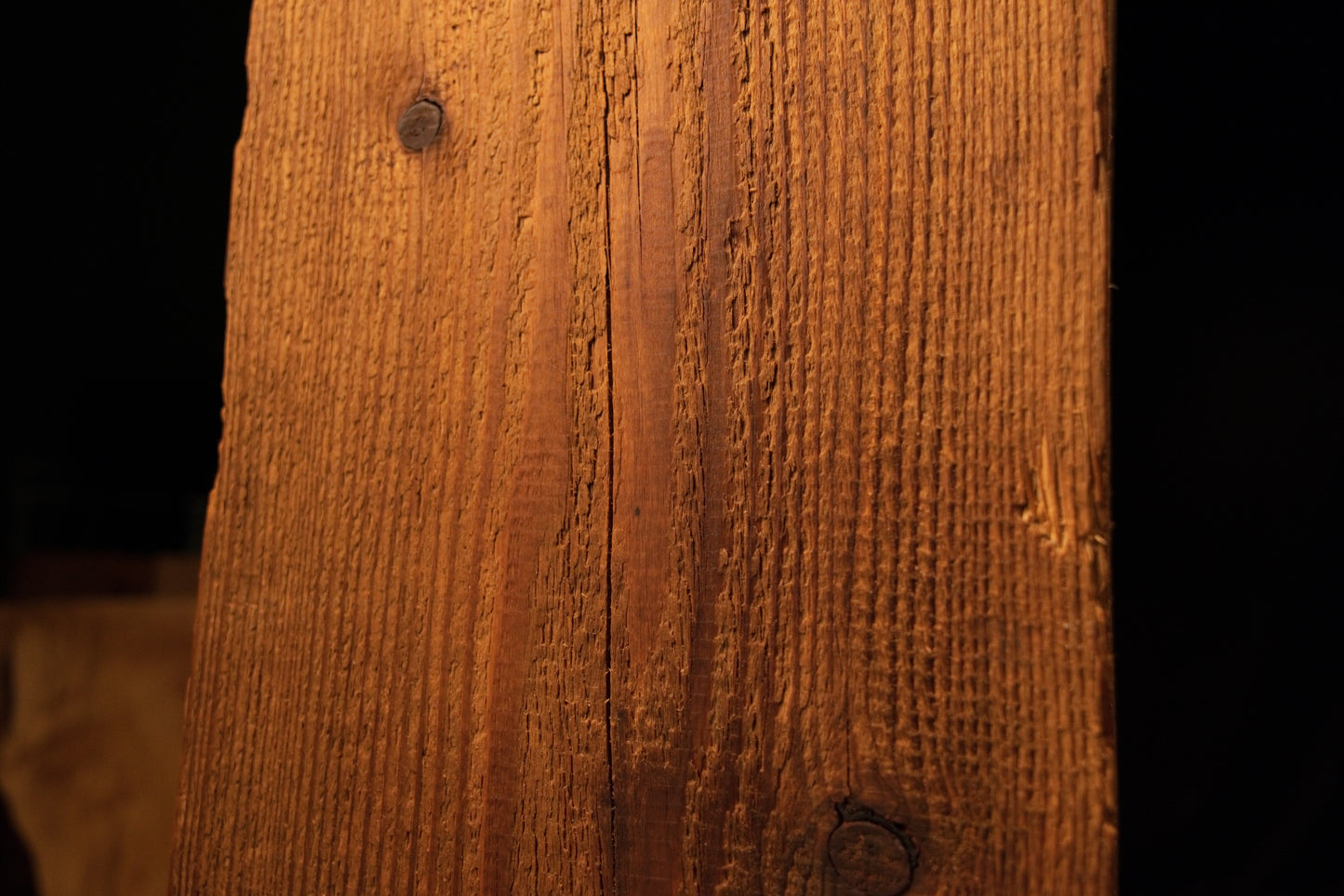 Close-up view of the upper beam section displaying linear grain textures and a single dark pinhole near the left edge. 