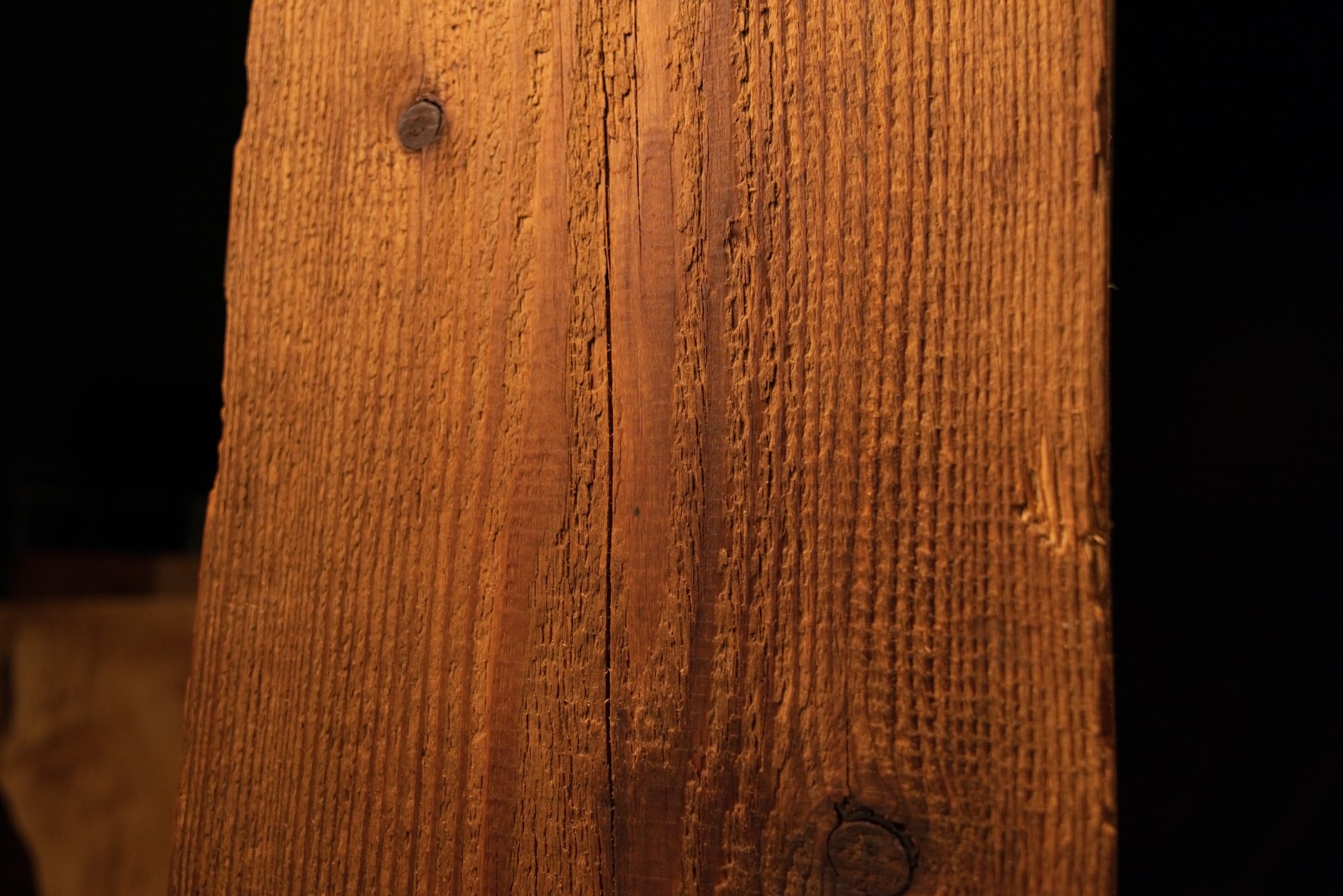 Close-up view of the upper beam section displaying linear grain textures and a single dark pinhole near the left edge. 