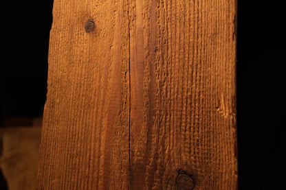 Close-up view of the upper beam section displaying linear grain textures and a single dark pinhole near the left edge. 