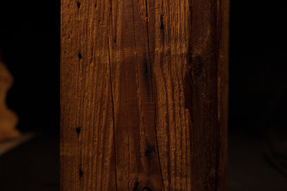 Detailed view of the lower beam section displaying weathered vertical grain textures and small dark pinholes. 