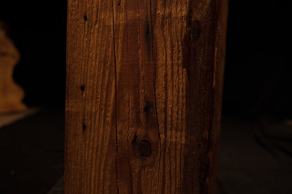 Macro photograph focusing on the lower-middle face of the wooden column with linear grain and minor blemishes. 