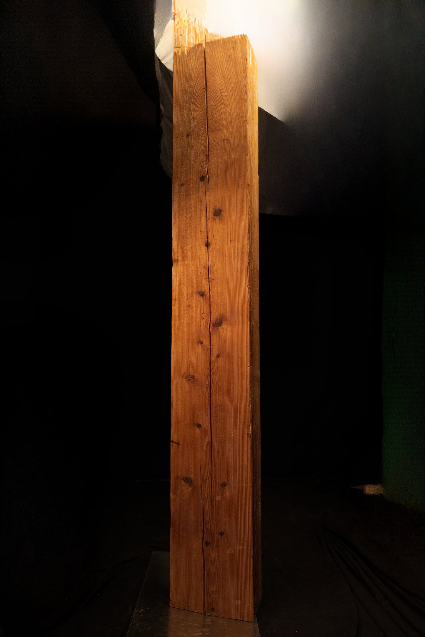 Frontal perspective of a floor-heating compatible wooden column showcasing a central vertical split and dark knots. 