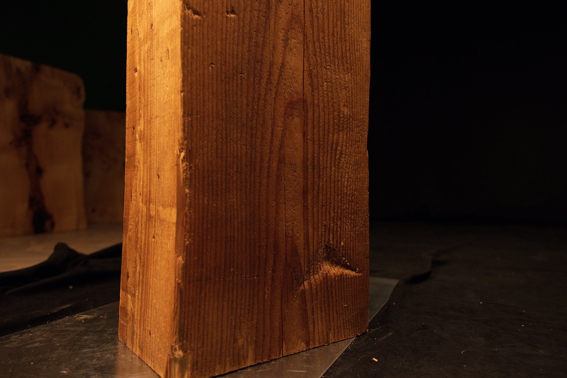 Lower section close-up of an epoxy-free architectural structural timber column resting flat upon a metal base. 