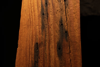 Detailed close-up view of scattered dark pinholes and minor vertical surface fractures along a timber element. 