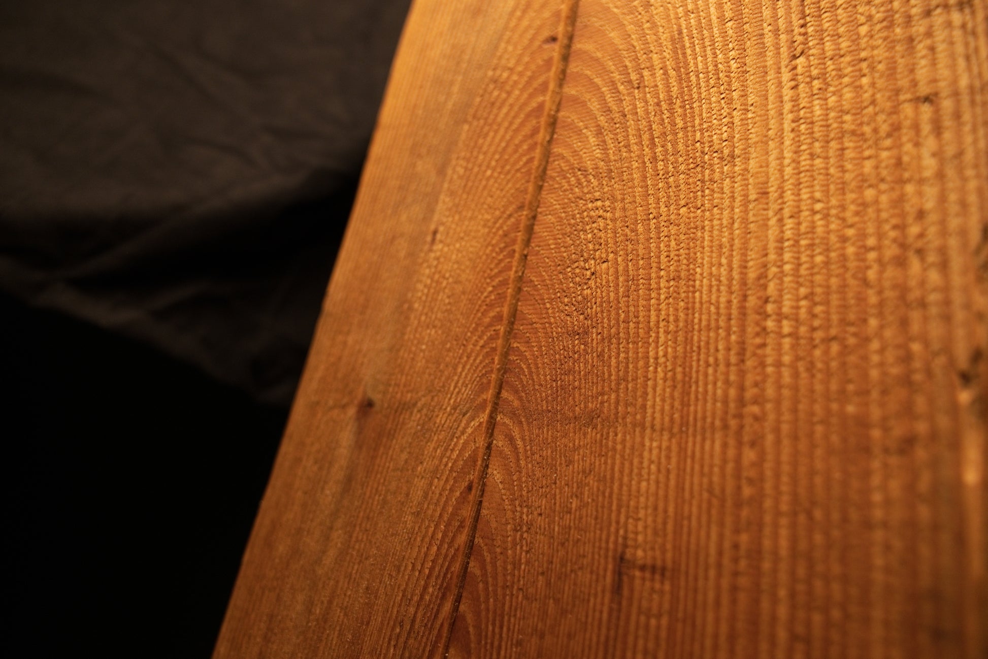 Detailed angled macro perspective highlighting vertical grain lines and a fine vertical split on a wooden column. 