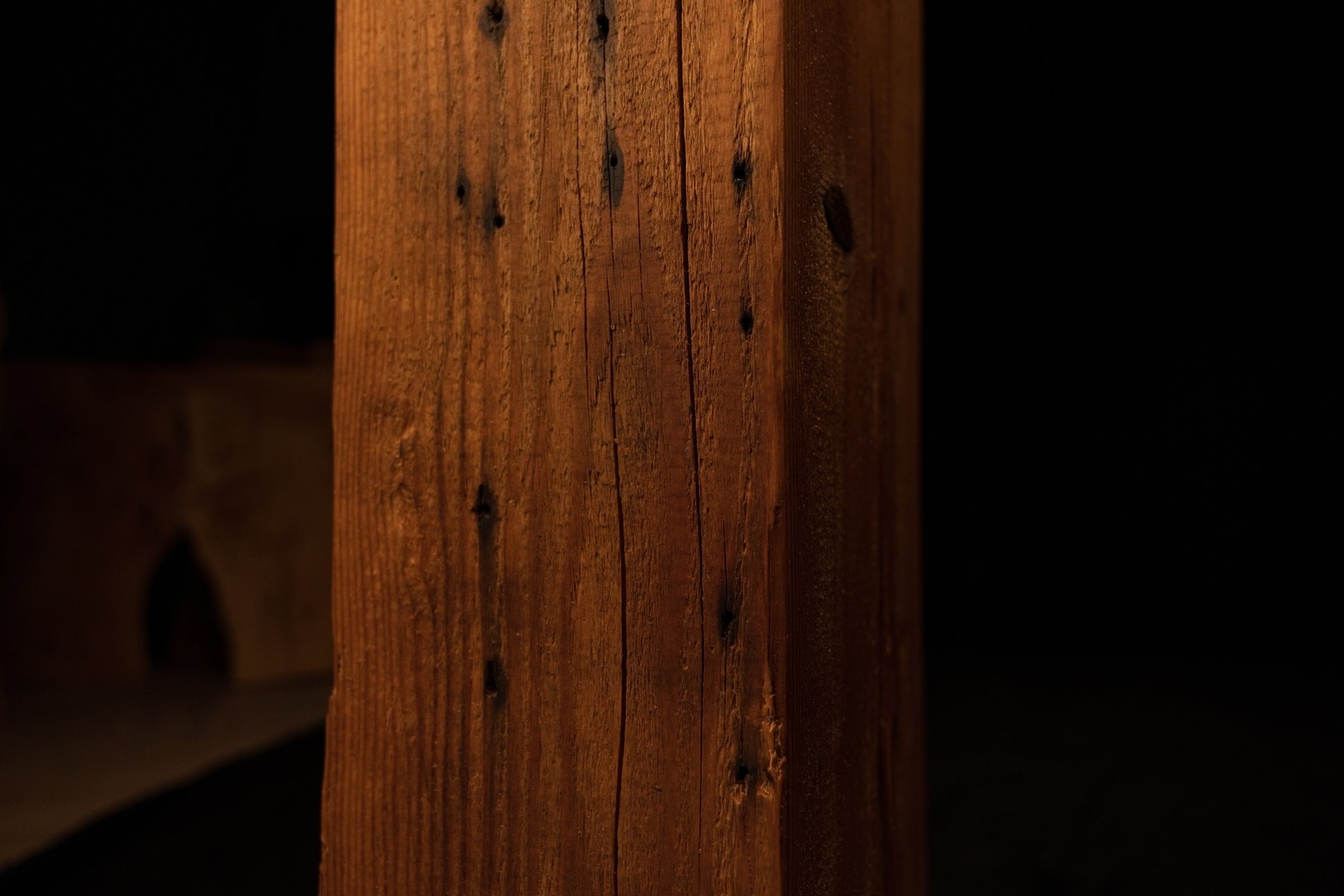 Detailed close-up of the lower-middle beam section showing straight vertical grain lines and dark organic pinholes. 