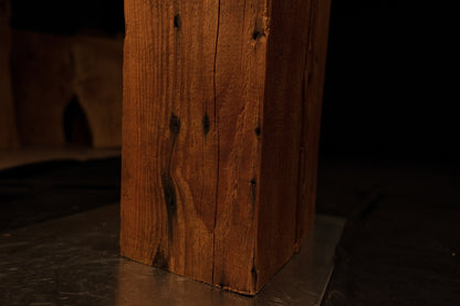 Detailed close view of the lower timber section near the base highlighting vertical grain and dark knot inclusions. 