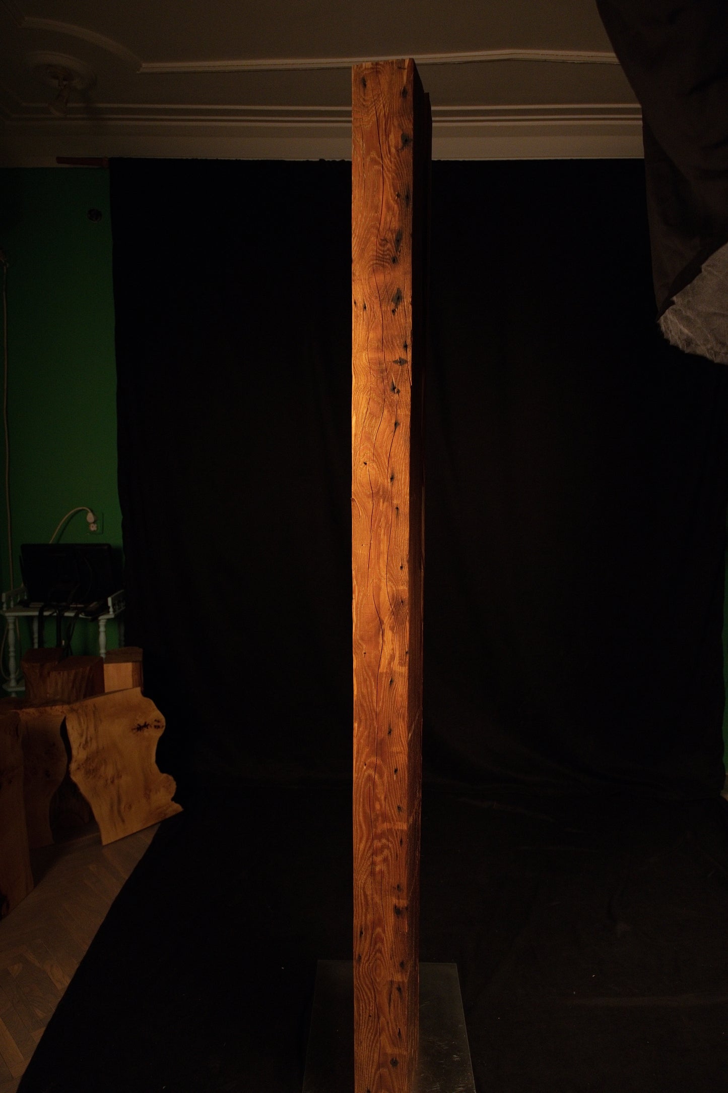 Vertical profile of an epoxy-free architectural timber beam illuminated in a studio setting with a green background visible. 