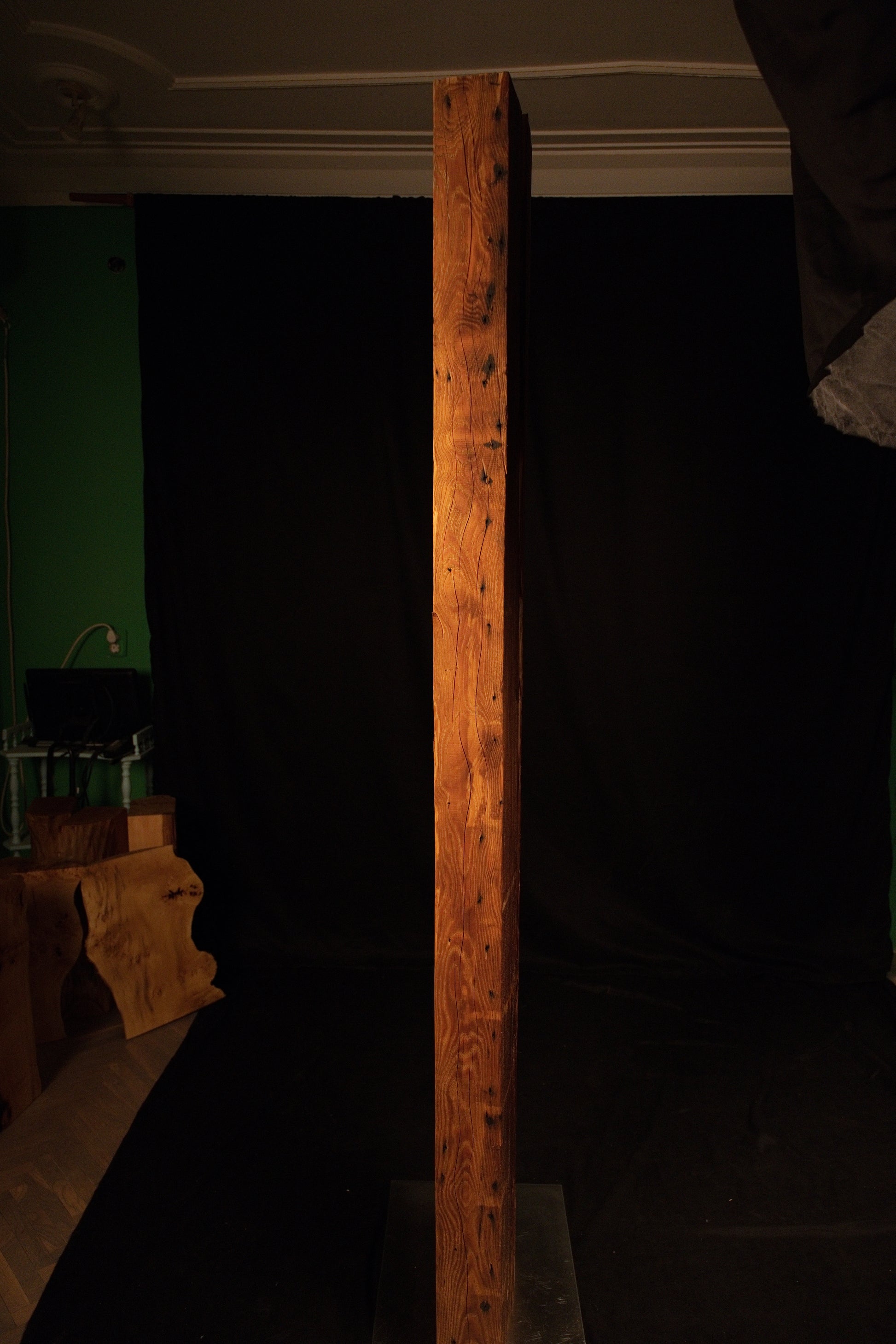 Vertical profile of an epoxy-free architectural timber beam illuminated in a studio setting with a green background visible. 